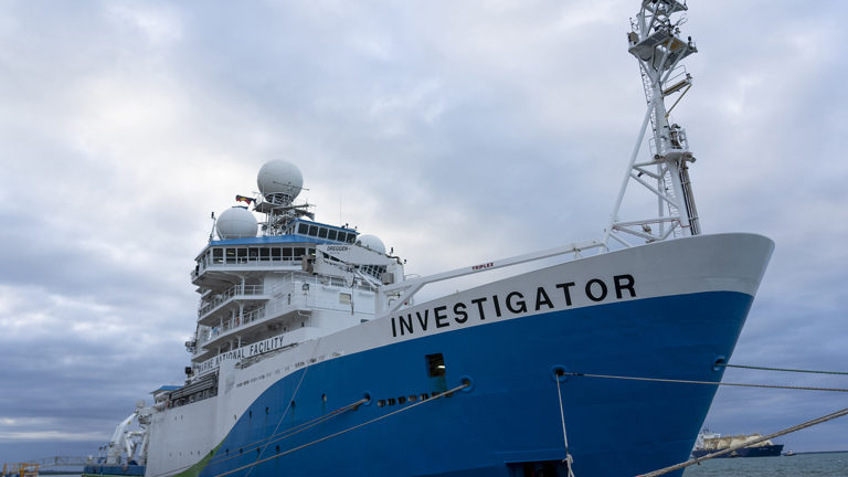 A large research ship sits at a dock in Darwin